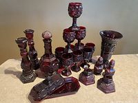 Full lot of 20 red glass Avon Cape Cod collection pieces including decanter, goblets, candle holders, butter dish, vase, and shakers.