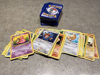 Stack of assorted Pokémon cards with character cards displayed showing names and attacks.