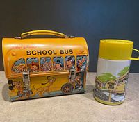 Front view of Walt Disney School Bus lunch box and matching thermos side by side on counter