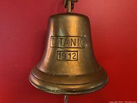 Close-up front view of bell showing raised “TITANIC 1912” stamp