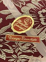 Close-up image of original Italian product label and ribbon on the coverlet.