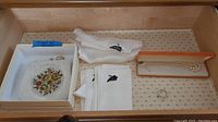 Lot contents showing vintage Du-Van clutch, three white silk scarves, faux pearl necklace and pin in case, and additional jewelry pieces.