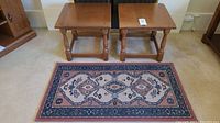 Two vintage Vilas solid wood side tables placed side by side on a carpeted floor with a multicolored oriental-style area rug in front of them.