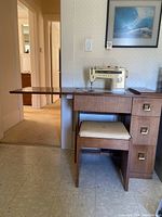 Side view of sewing machine table showing fold-out leaf extended