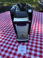 Front view of Keurig coffee maker showing the drip tray and front panel with Keurig logo.