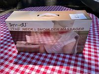 Packaged box for IkneadU iTap Neck & Shoulder Massager showing product image and branding.