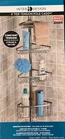 Photo of the assembled caddy installed in a shower showing the 4 wire shelves holding toiletries and a bath pouf.