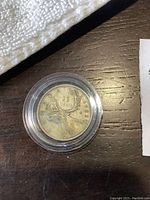 1953 Canadian silver quarter reverse side showing caribou and date in plastic protective case.