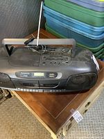 Panasonic stereo CD system with handle, antenna, and cassette decks sitting on a wooden table.