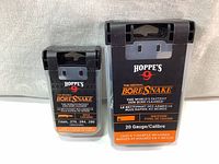 Front view of two Hoppe's 9 Original Bore Snake cases, showing product branding for 20 Gauge shotgun and 7mm-.280 rifle calibers.