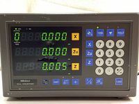 Front view showing powered-on digital display and keypad with various buttons, visible cosmetic wear on casing.