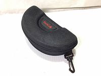 Closed black Bolle hard case with belt hanging clip and red logo patch displayed against white background.