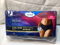 Front view of sealed Tena Stylish Black Women’s Incontinence Underwear package sized S/M with 18 pieces showing brand, absorbency level, and product features.