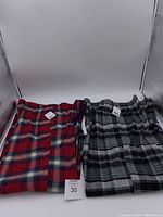Two pairs of men's George pyjama pants side by side, showing red plaid and black/grey plaid designs.