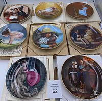 All 8 decorative collector plates laid out together, some plates in original boxes, showing various illustrated scenes.