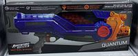 Front view of the Adventure Force Tactical Strike Quantum motorized ball blaster in its packaging showing the full length of the blaster and the orange ball chamber.