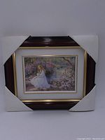 Front view of framed picture with corner packaging protectors showing the wood frame and image.