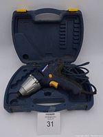 Mastercraft cordless impact drill placed inside its molded plastic carrying case with a coiled power cord visible.
