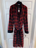 Front view of the red and black buffalo plaid fleece robe with waist belt and front pockets.