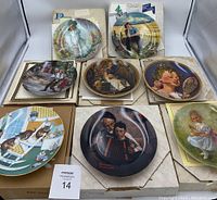8 collectible plates arranged with some boxes and certificates visible. Plates depict various illustrations including children, music themes, and portraits.