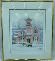 Full view of framed art print depicting a pink Victorian mansion in winter with horse and carriage, showing overall condition and frame.