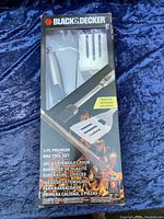 Front view of boxed Black & Decker 3-piece BBQ tool set showing spatula, fork and basting brush