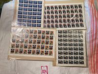 Five sheets of Canadian mint postage stamps laid flat on a surface, all in original packaging, showing different historic and thematic designs.