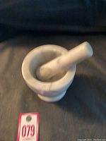 Top angled view of white marble mortar with pestle inside, showing size and clean condition