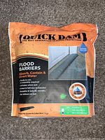 Front view of sealed Quick Dam Flood Barrier bag showing product name, features, and size.