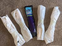 Photo showing four butterfly kites wrapped in white bags and one in blue packaging.
