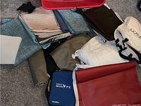 Large red plastic bin containing folded leather and fabric materials, seen from a higher angle to show assortment.