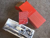 Sous vide cooker sealed in plastic inside white styrofoam tray with KLARSTEIN manual and open orange box visible