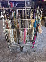 Full front view of tri-level rack holding diverse assortment of necklaces and jewelry pieces