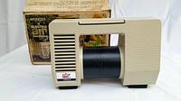 Side view of beige Webster Electro Air portable air compressor with original box behind