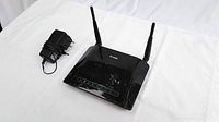 D-Link DIR-815 router with attached antennas and power adapter positioned on white background.