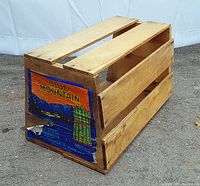 Side view of the vintage wooden produce crate showing Blue Mountain branded asparagus label and natural wood slats.