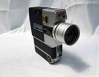 Side angle showing camera body with lens and pistol grip handle