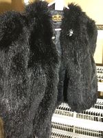 Front angle view of black vintage fur jacket showing plush fur texture and collar area with label.