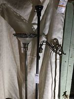 Three floor lamp columns standing, one with pressed glass shade and metal gallery