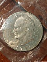 Obverse of 1971 Eisenhower dollar showing portrait of Eisenhower, date and inscriptions, sealed in plastic.