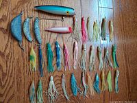 Full view of all items showing trolling plugs, weighted trolling jigs, and various soft plastic hoochie lures in assorted colors.