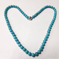 Full necklace laid in a heart shape on white background