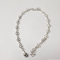 Silver anklet with circular linked loops chain, polished round bead, and hook clasp