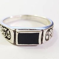 Front view of silver ring showing rectangular black onyx stone and floral engraved sides.