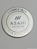 Obverse of silver coin showing Asahi Refining logo, 1 OUNCE TROY text, and FINE SILVER 999 purity marking.