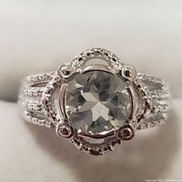 Close-up front view of the silver green amethyst ring showing the gemstone and ornate bezel setting.