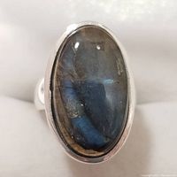 Front view showing the oval labradorite stone with blue iridescence set in silver bezel.