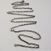 Silver box chain necklace laid out showing length and clasp details.