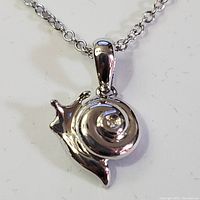 Front view of silver rhodium plated snail pendant with diamond accent on chain.