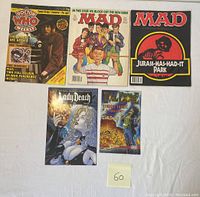 Five magazines and comics laid out flat, including Doctor Who Weekly, two MAD magazines, and two Lady Death comics.